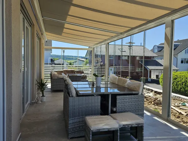 Glasschiebewand als Seitenwand an einem Terrassendach