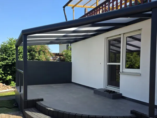 Alu-Terrassendach über einer erhöhten Terrasse mit runden Stufen